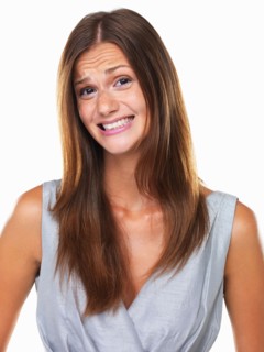 Studio portrait of woman with fake smile. Photo : momentimages