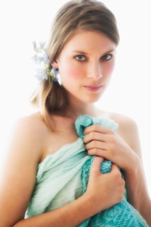 Studio portrait of young woman holding towel.