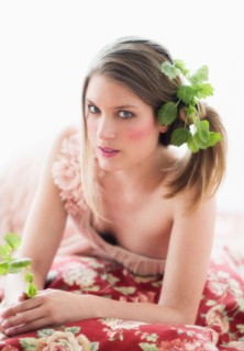Studio portrait of young woman with flowers in hair.