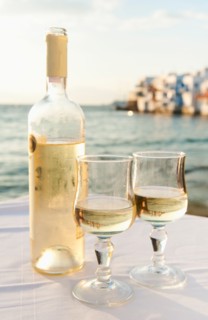 Greece, Cyclades Islands, Mykonos, Wine on table by sea.