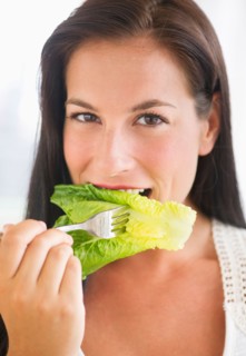 Portrait of woman eating lettuce.