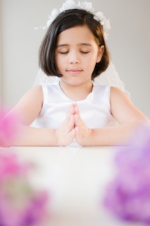 Portrait of girl (8-9) praying during Fist Communion. Photo : Jamie Grill