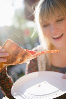 USA, Brooklyn, Williamsburg, Woman eating pizza. Photo : Jamie Grill