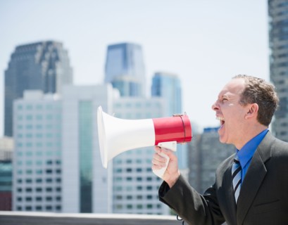 USA, New Jersey, Jersey City, Businessman shouting through megaphone. Photo : Jamie Grill