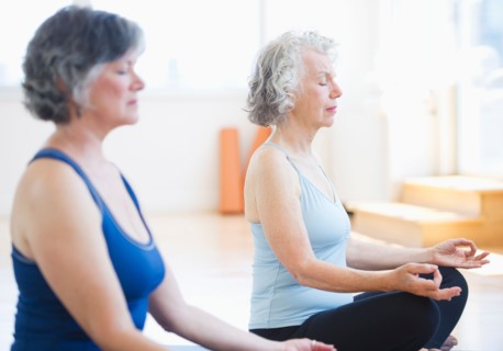 Two senior women practicing yoga. Photo: Daniel Grill