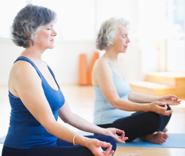 Two senior women practicing yoga. Photo: Daniel Grill