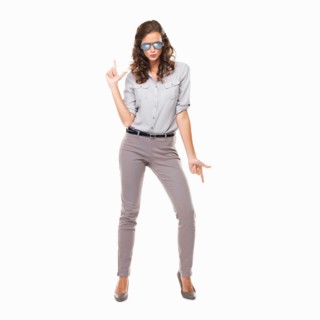 Studio shot of woman with glasses with hands shaped like gun. Photo : momentimages