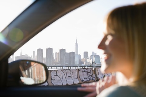 USA, Brooklyn, Williamsburg, Woman driving through city. Photo: Jamie Grill