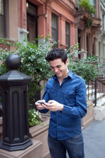 USA, New York, New York City, Young man texting on street. Photo : Winslow Productions