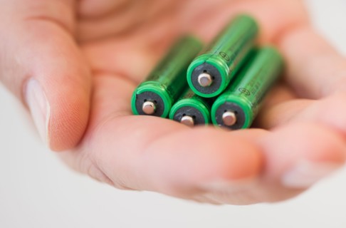 Hand holding batteries.