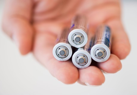 Hand holding batteries.