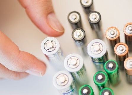 Hand holding batteries.