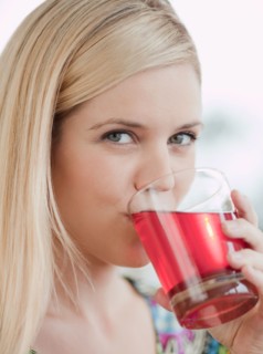 Portrait of young woman drinking juice. Photo : Jamie Grill