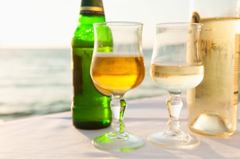 Greece, Cyclades Islands, Mykonos, Beer and wine on table by sea.