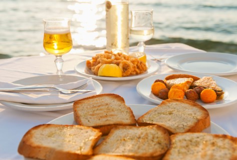 Greece, Cyclades Islands, Mykonos, Calamari appetizer on set table by sea.