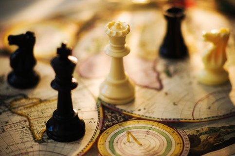 Chess pieces on old world map.