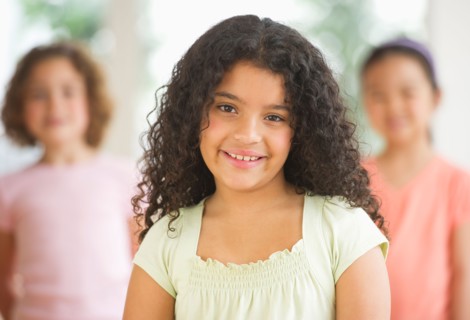 Portrait of girl (8-9) with friends.