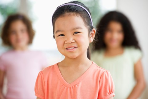 Portrait of girl (6-7) with friends.