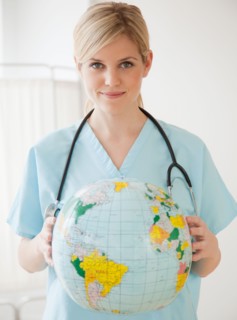 Young nurse holding globe. Photo : Jamie Grill