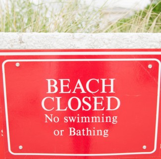 USA, New York, Queens, Rockaway Beach, close up of warning sign about closed beach. Photo : Jamie