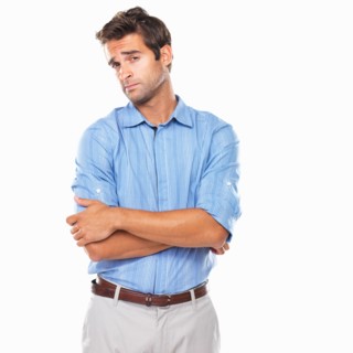 Portrait of curious executive standing with hands folded. Photo : momentimages