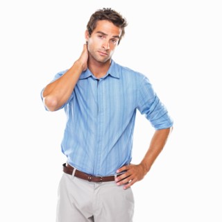 Portrait of business man standing with hand behind neck. Photo : momentimages