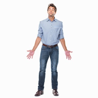 Studio shot of young man with chin up and palms out standing on white background. Photo :
