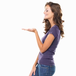 Studio shot of attractive young woman gesturing and smiling. Photo : momentimages