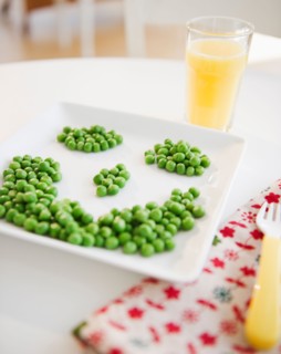 Close up of smiley on plate made of green peas. Photo : Jamie Grill