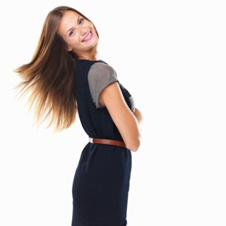 Portrait of pretty woman standing with hands folded and smiling. Photo: momentimages