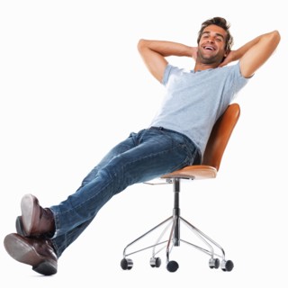 Portrait of young man relaxing on chair with hands behind head and smiling against white background