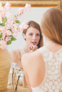 Young woman in front of mirror. Photo : Daniel Grill