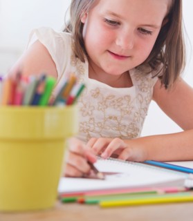 Close up of girl (6-7) drawing in notebook. Photo : Daniel Grill