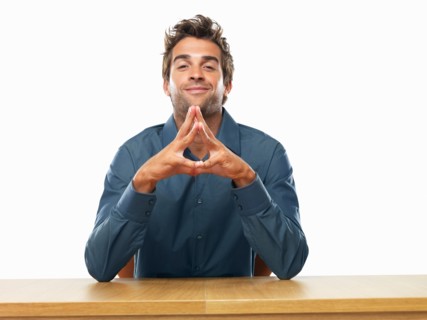 Smiling business man sitting at table and gesturing. Photo: momentimages