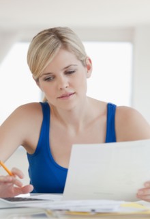 Young blond woman doing paperwork. Photo : Jamie Grill