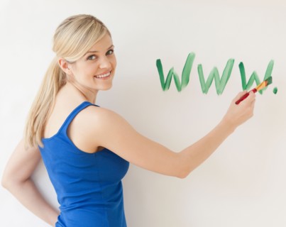 Blonde young woman writing web address on wall. Photo : Jamie Grill