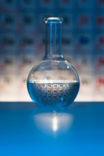 Beaker with periodic table in laboratory.
