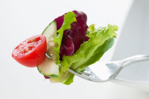 Fresh salad on fork.