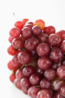 Fresh red grapes on white background.