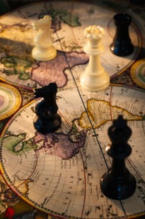 Chess pieces on old world map.