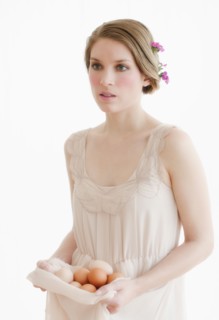 Young woman carrying basket of eggs.