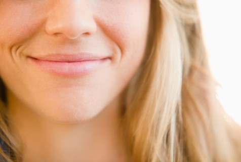 Close up of mouth of smirking woman. Photo : Jamie Grill