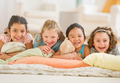 Portrait of girls (6-9) relaxing on pillows.