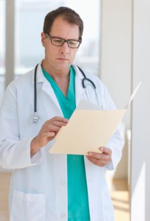 Doctor writing in clipboard.