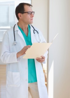 Doctor writing in clipboard.
