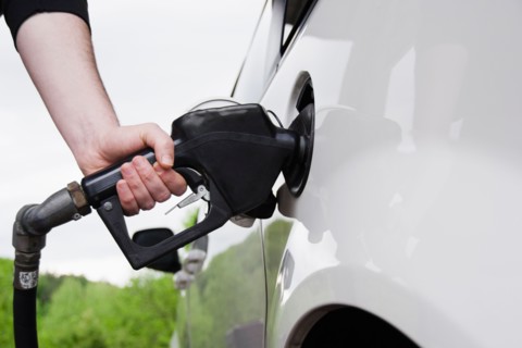 Close up of man's hand holding fuel pump and refueling car. Photo : Jamie Grill