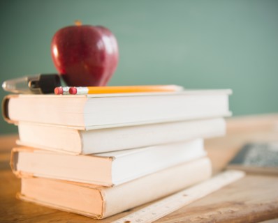Close up of school equipment with books and apple. Photo : Jamie Grill