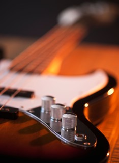 Close up of volume knobs of bass guitar. Photo : Daniel Grill
