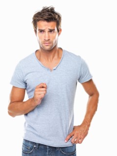 Studio shot of young man with furrowed forehead looking away. Photo: momentimages