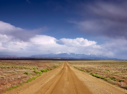 USA, Utah, Dirt road crossing landscape. Photo: John Kelly